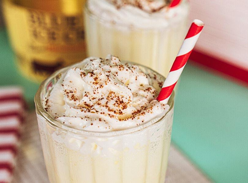 close up of an eggnog milkshake with whipped cream and nutmeg