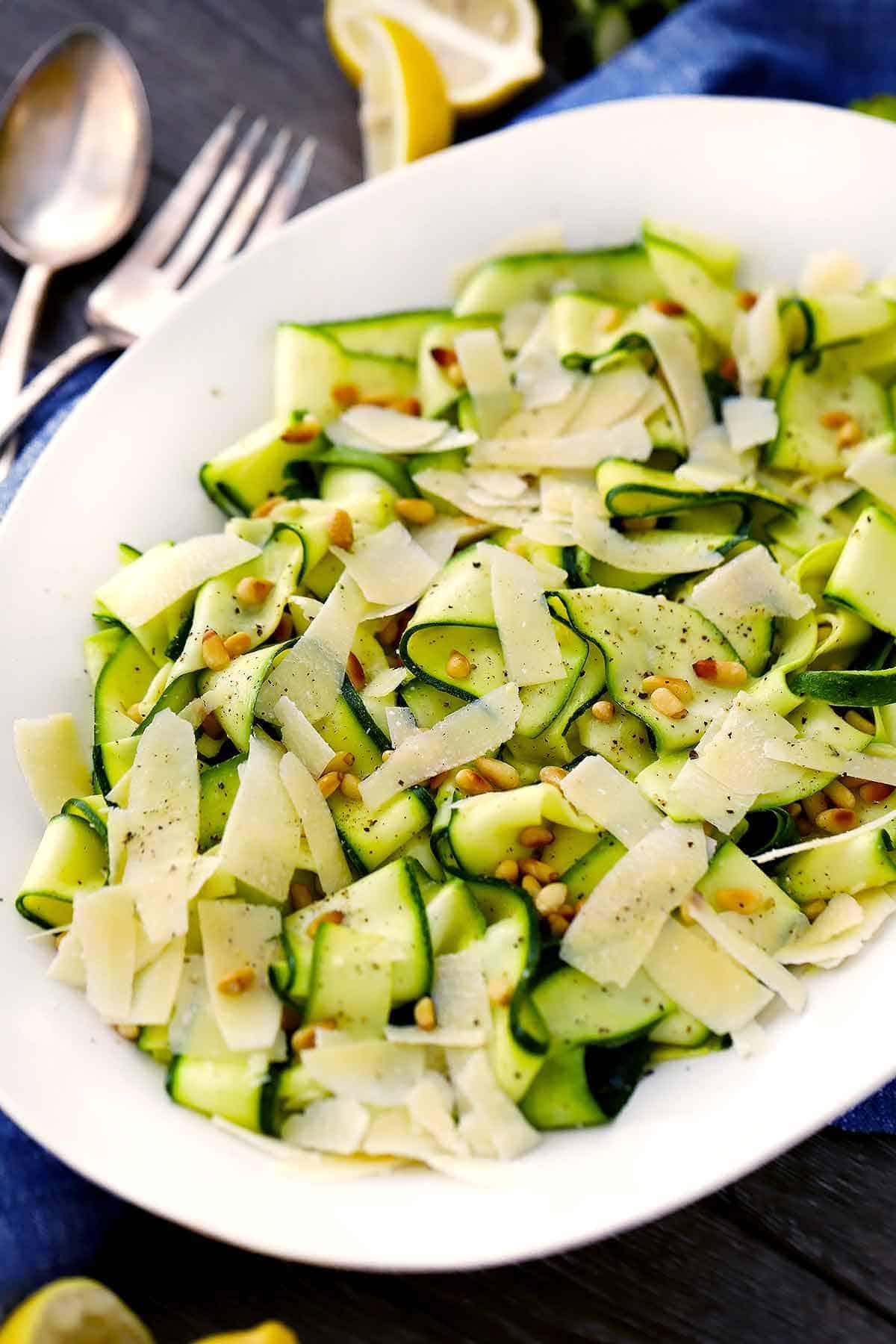 close-up of zucchini ribbon salad with lemon vinaigrette being drizzled on top