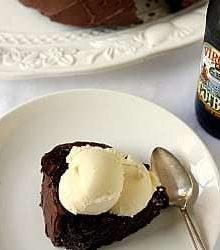 a slice of root beer float cake sitting on a plate, with a spoon beside it
