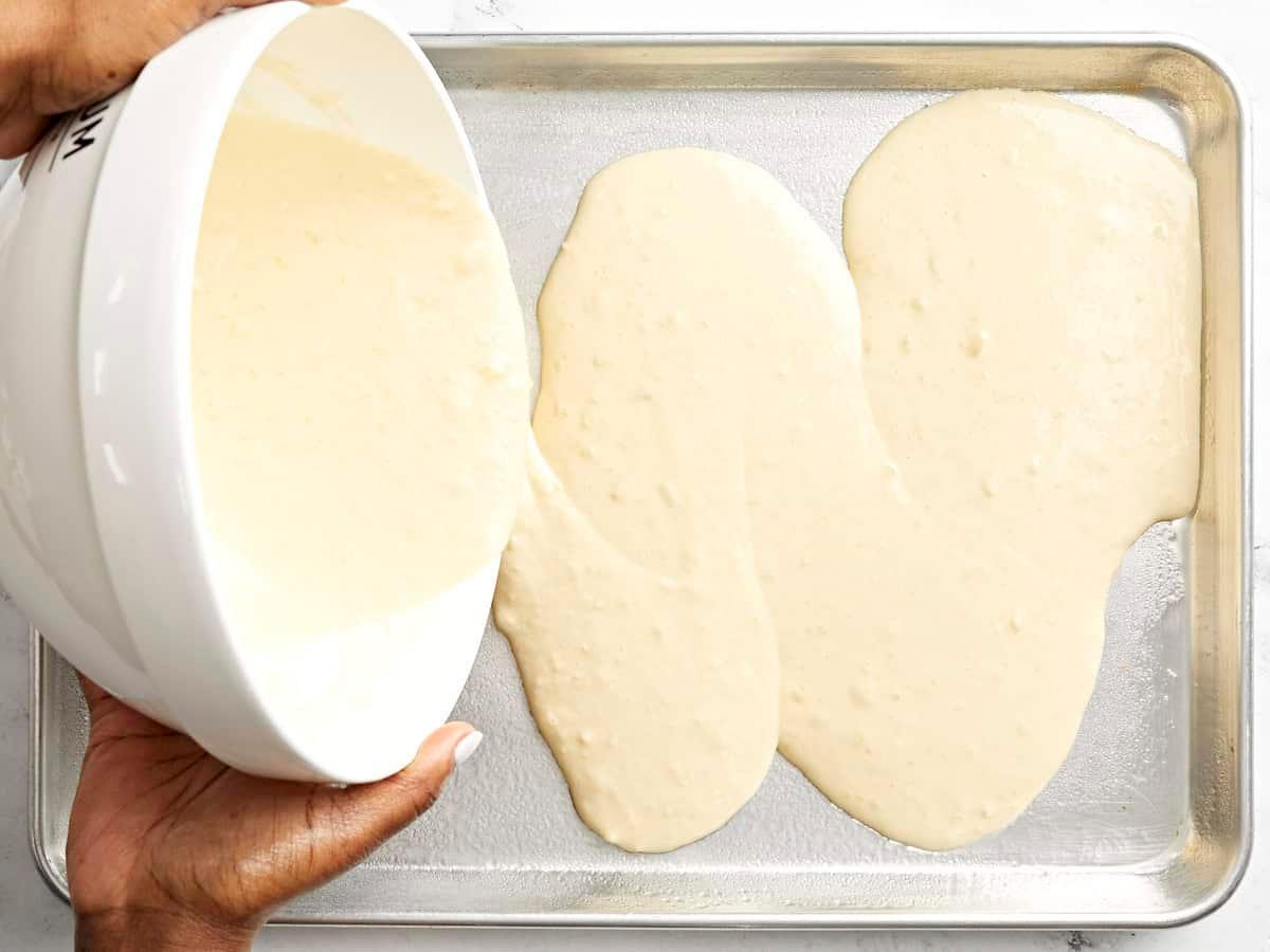 blended pancake batter being poured onto a sheet pan