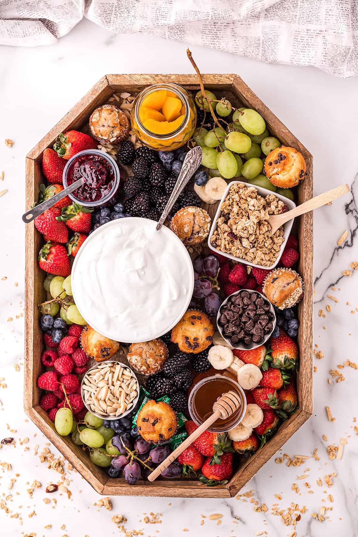 ingredients for raspberries and cream yogurt parfait arranged on a table
