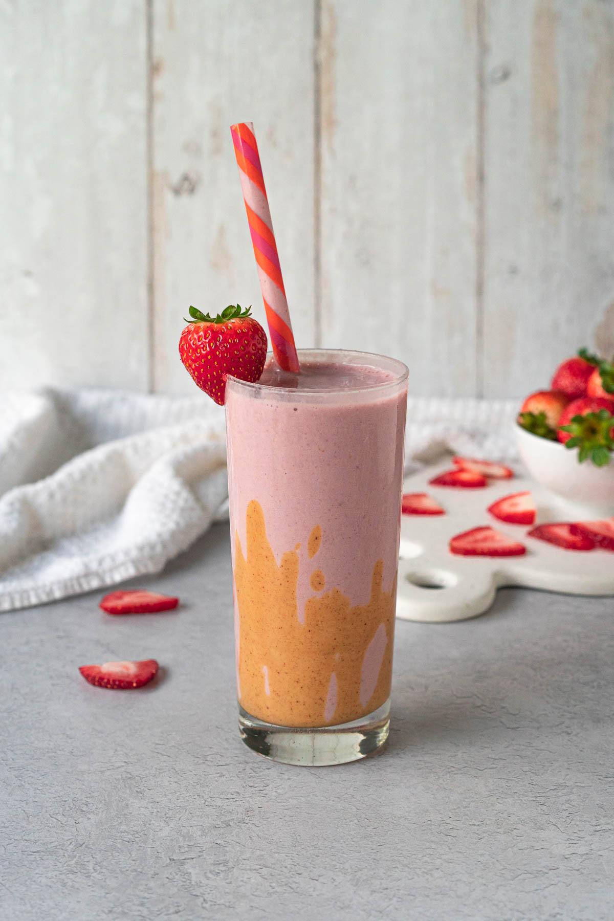 a vibrant strawberry peanut butter smoothie in a glass