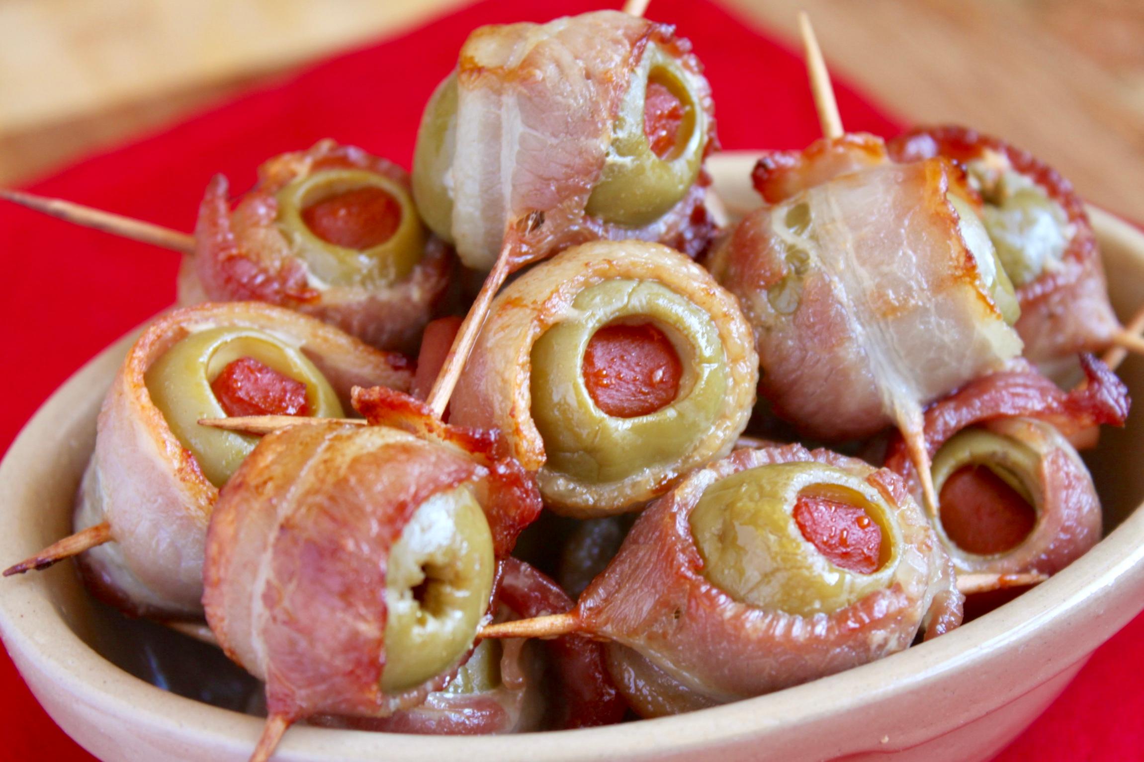 bacon wrapped olives with cream cheese on a serving platter