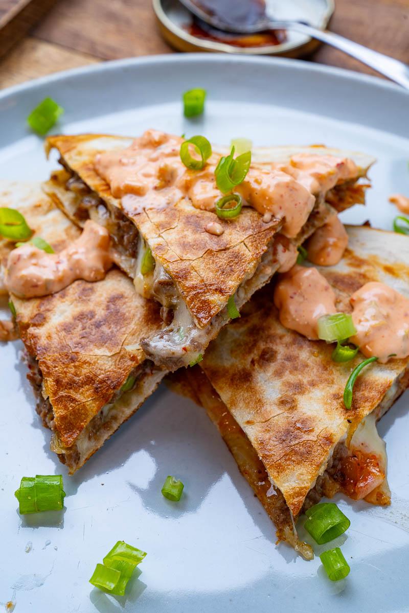Close-up of a Korean BBQ beef quesadilla with kimchi being cut into wedges