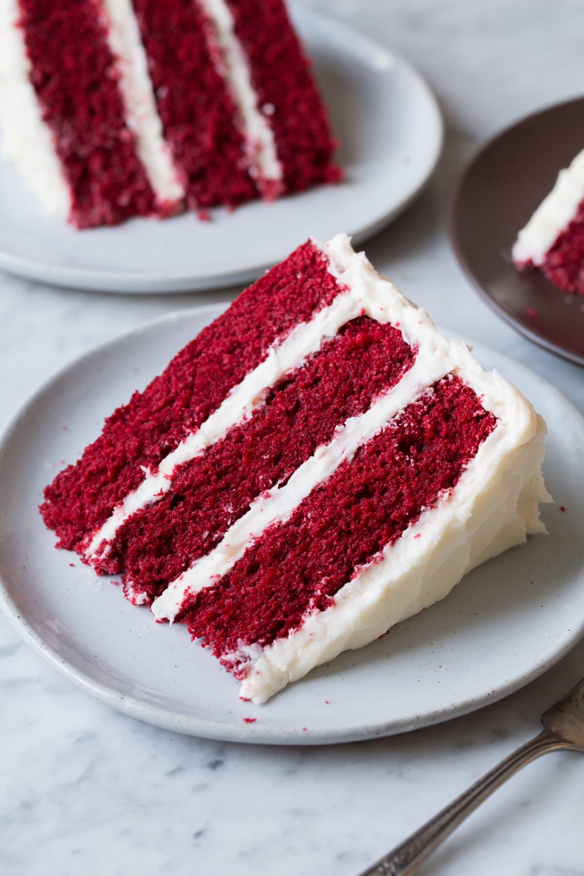 red velvet cake slice with cream cheese frosting on a plate