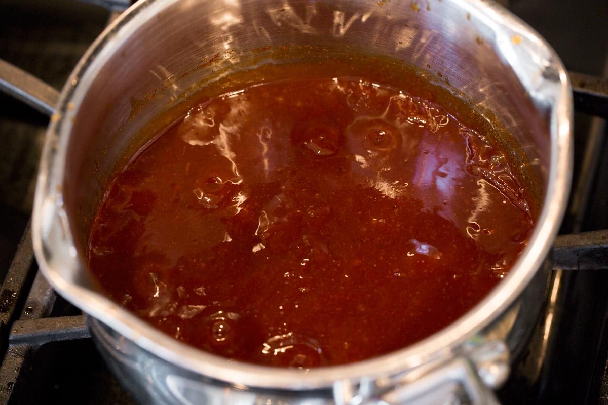 Close-up of apple cinnamon BBQ sauce simmering in a saucepan