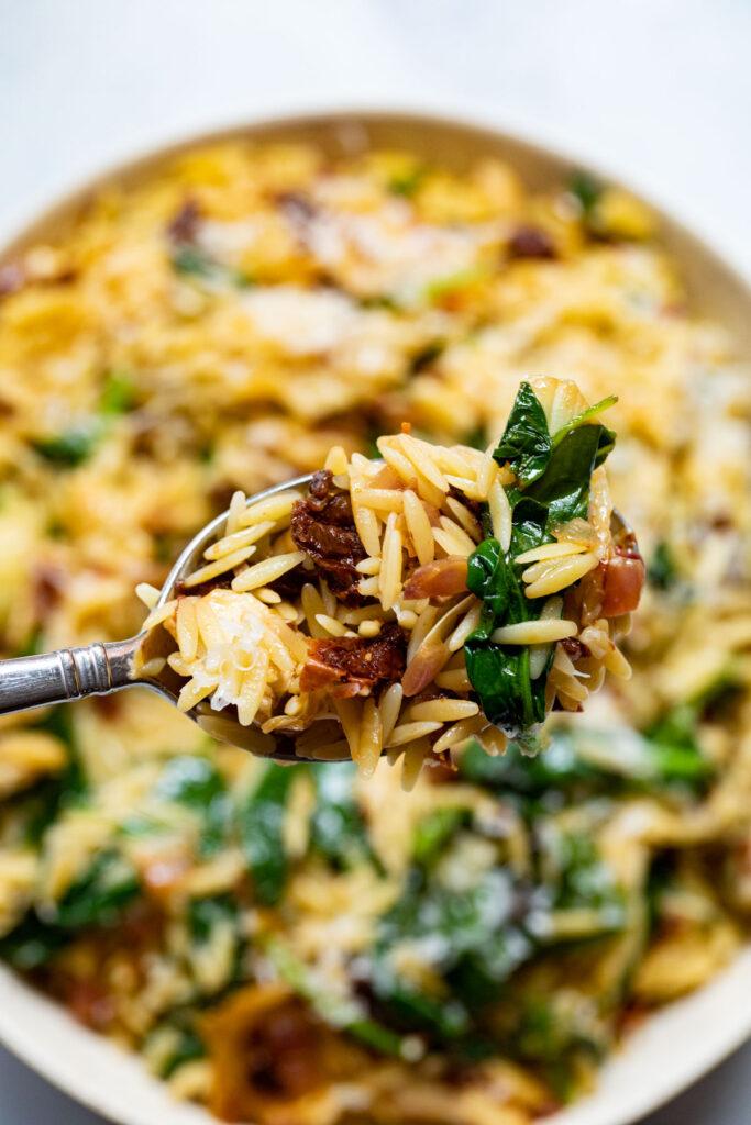 Close-up of Spinach and Artichoke Orzo Pasta Salad, highlighting the textures and colors