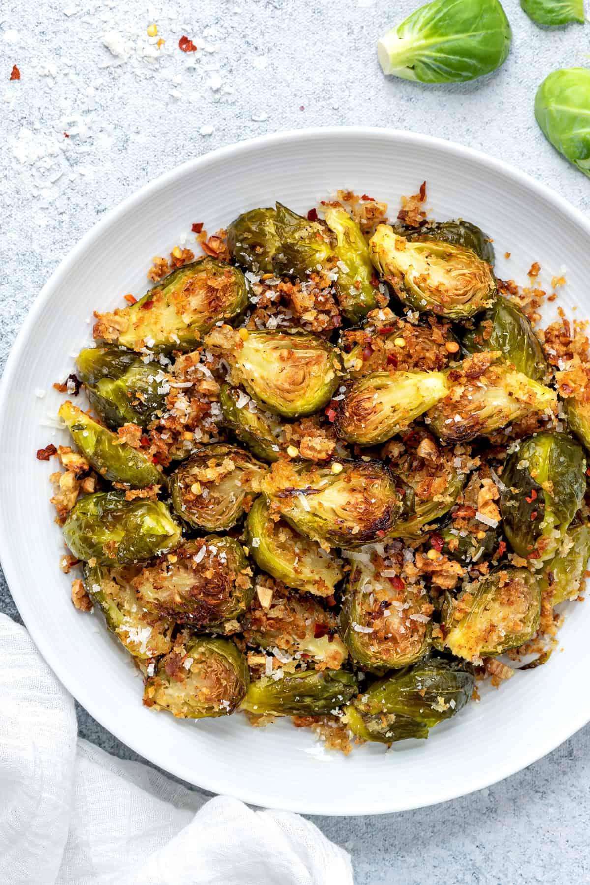 close-up of roasted Brussels sprouts with breadcrumbs being served on a plate