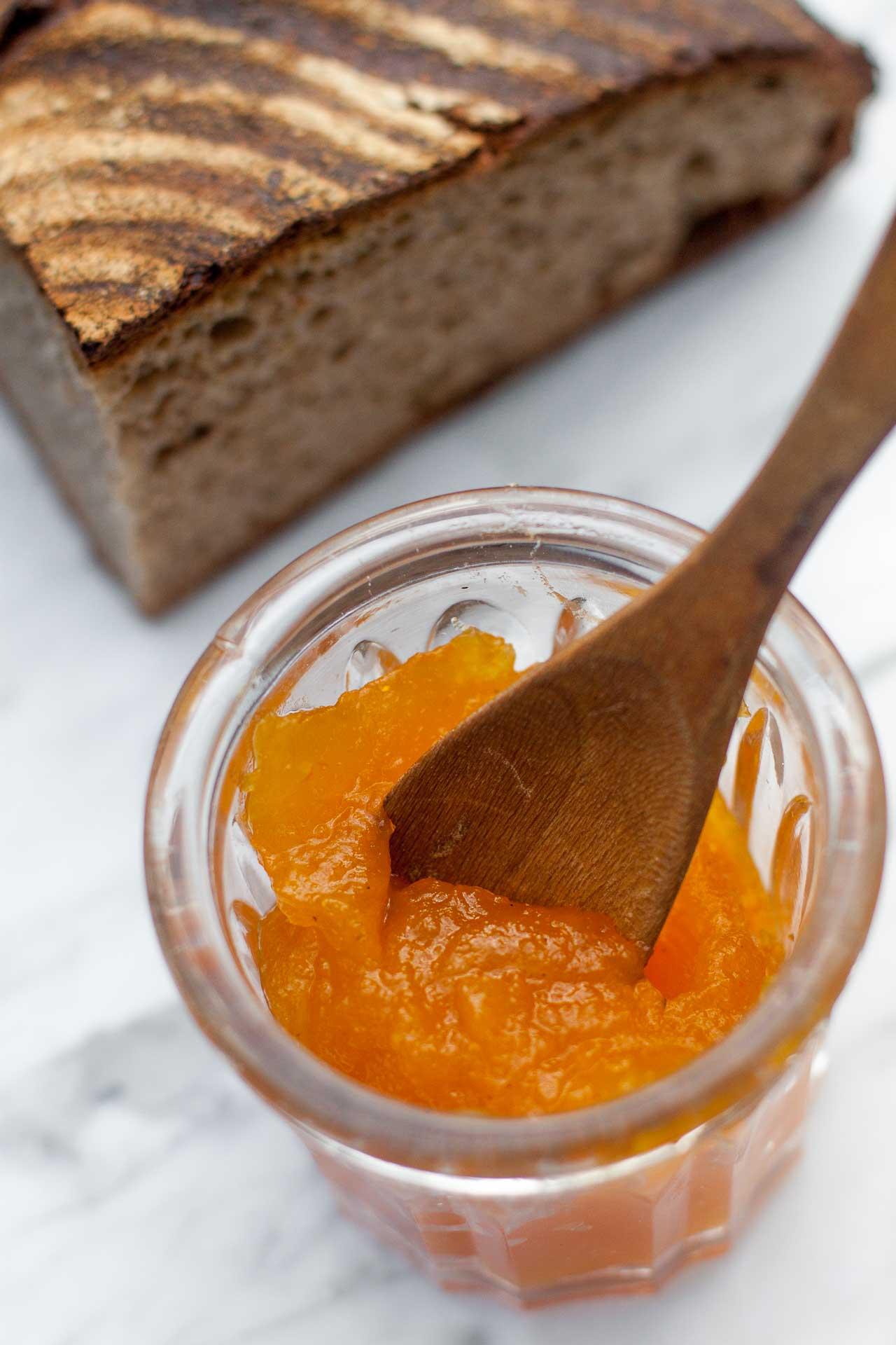 a close-up of freshly made pumpkin spice rhubarb jam being spread on a slice of toast