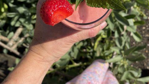 person enjoying a strawberry sunrise lassi outdoors