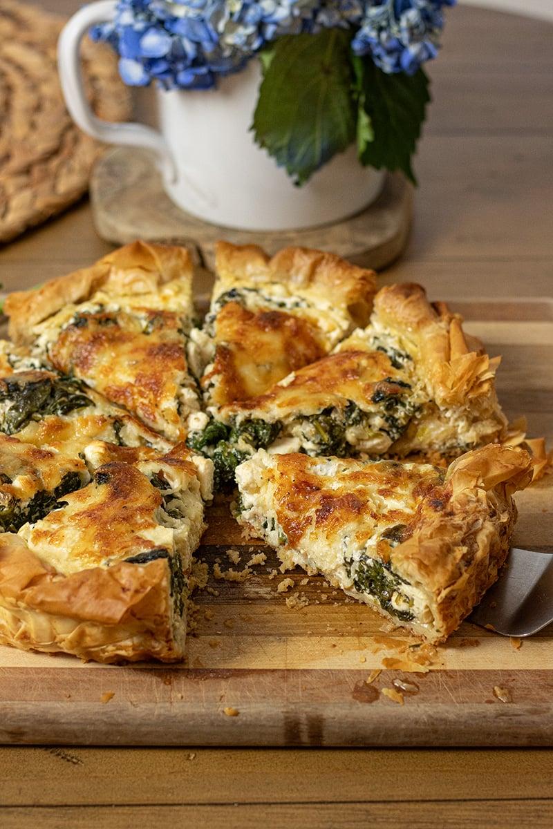 egg and spinach quiche with feta cheese on a rustic wooden table