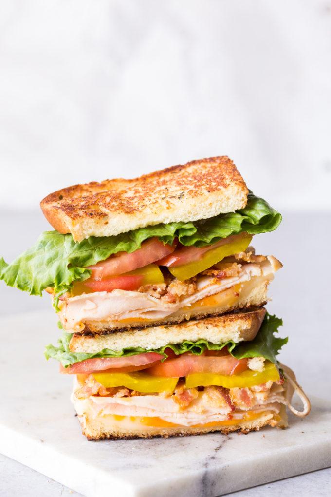 a stack of chicken parmesan club sandwiches cut in half, showing the layers