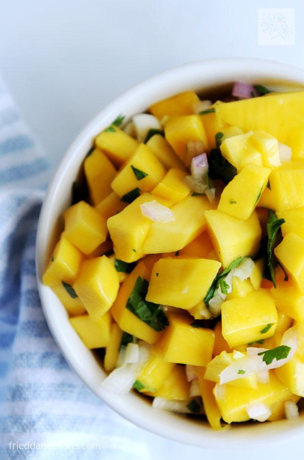 close-up shot of mango salsa with crispy fried shallots in a colourful bowl
