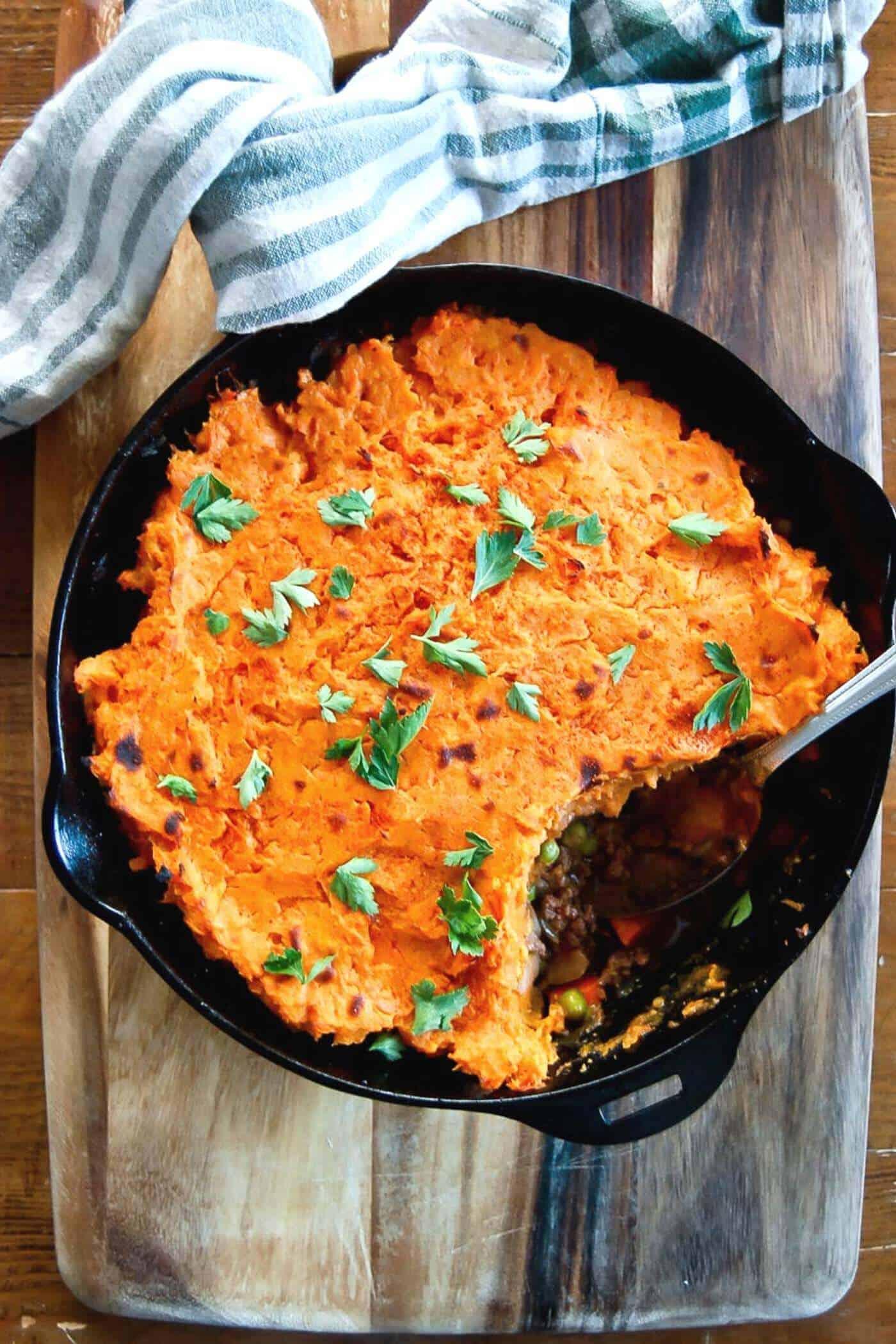 sweet potato topping being spread on pork and bacon shepherd's pie