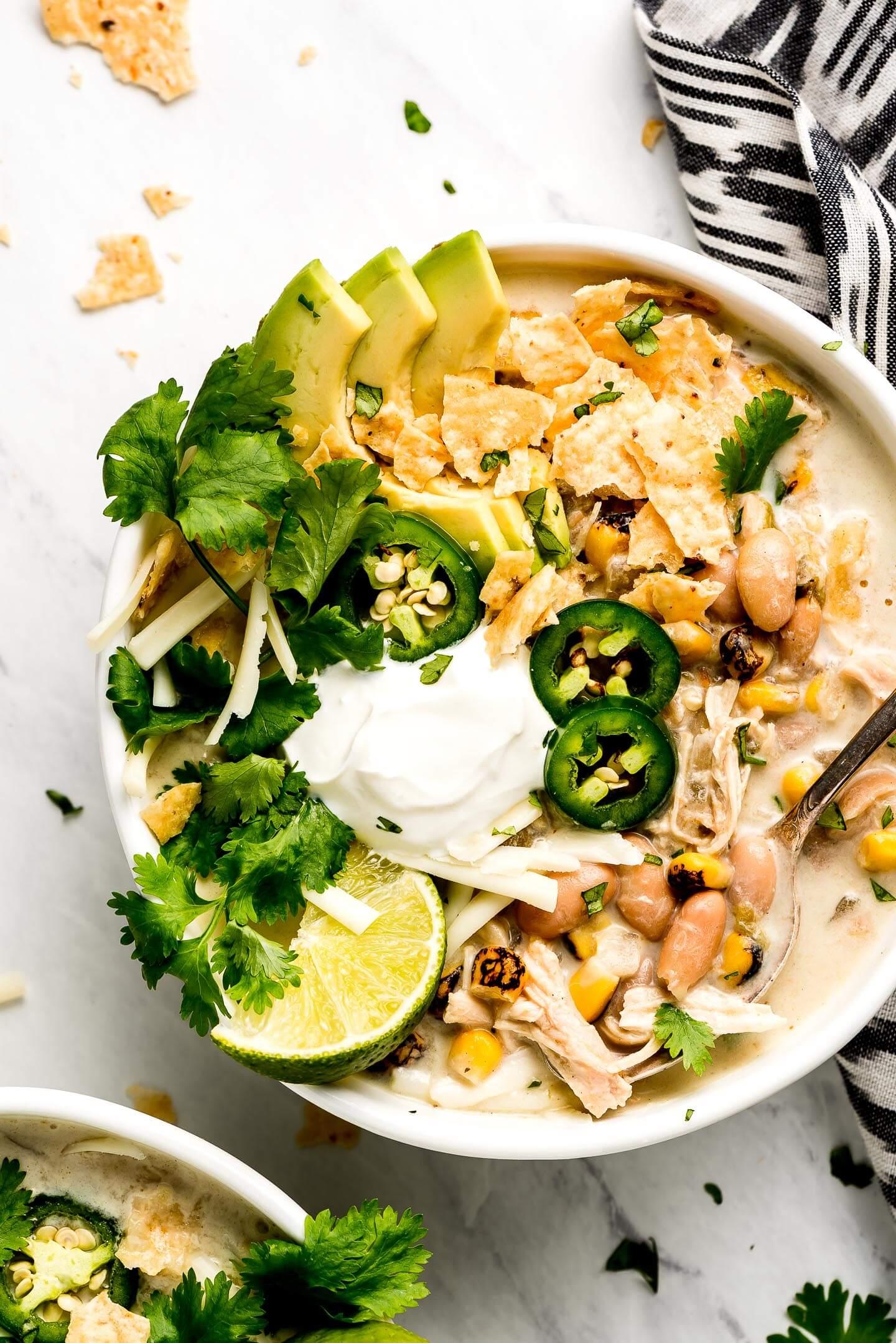 bowl of white chicken chili with mussels garnished with cilantro