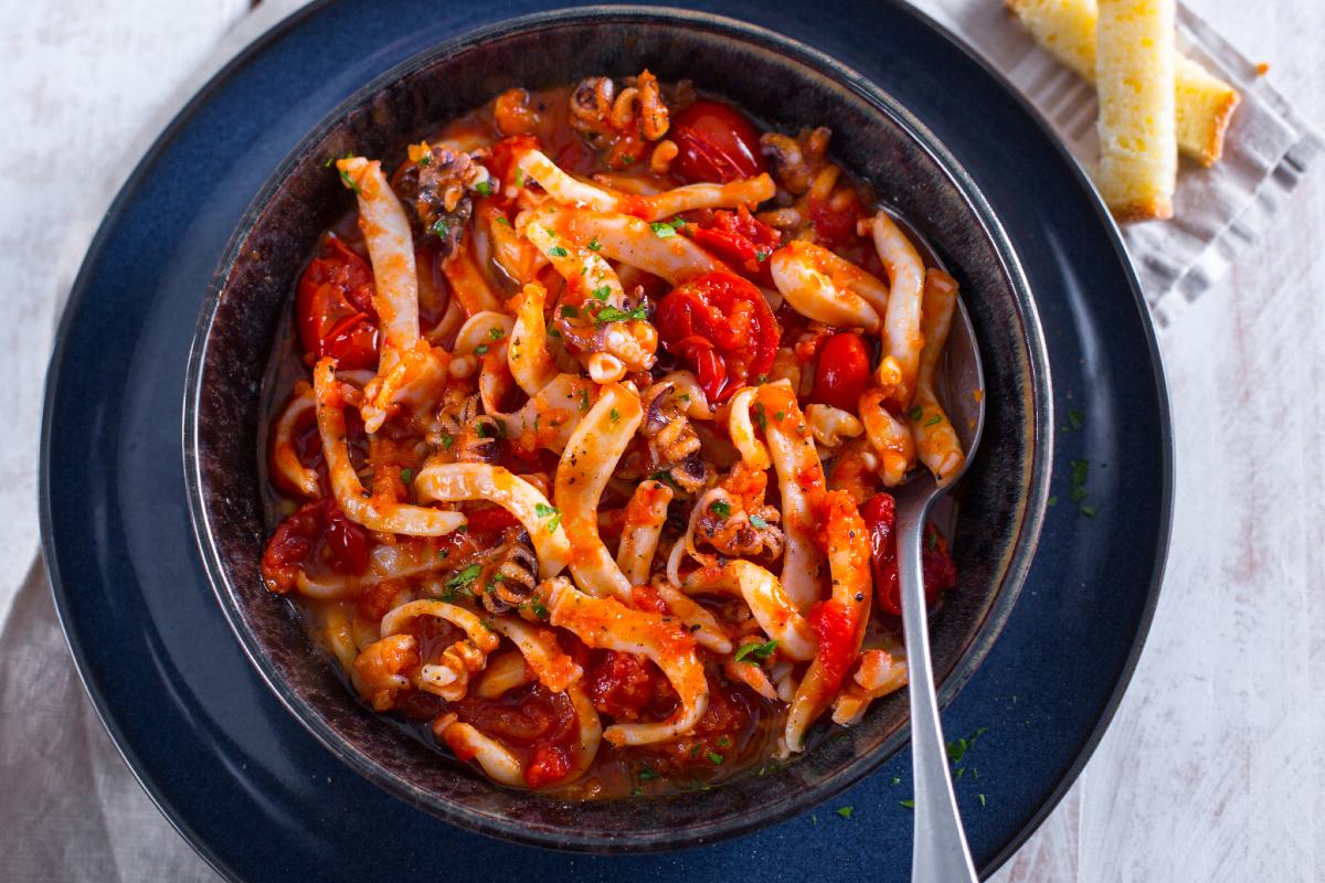 Close-up of cuttlefish stew with visible cuttlefish tentacles and tomato sauce