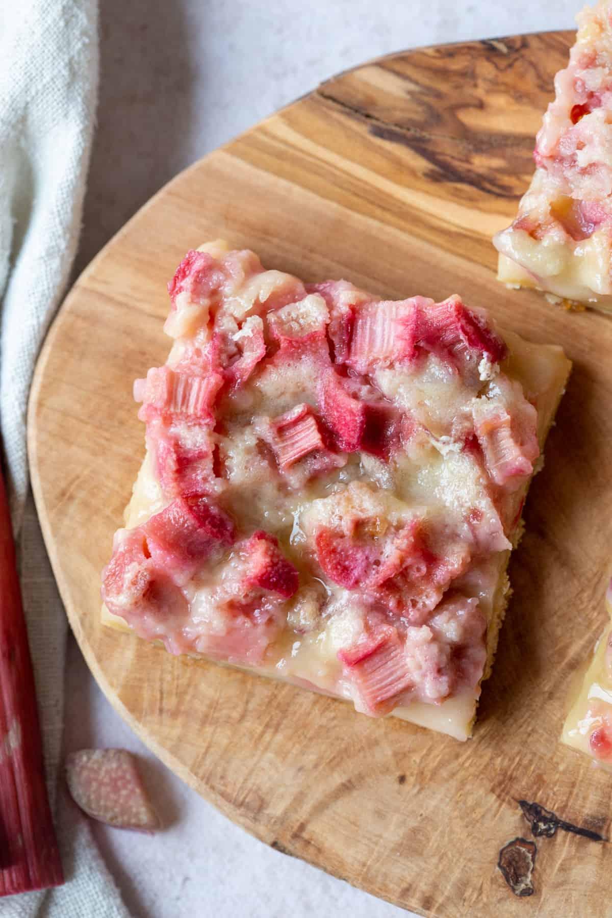 rhubarb polenta bars freshly baked on a wooden cutting board