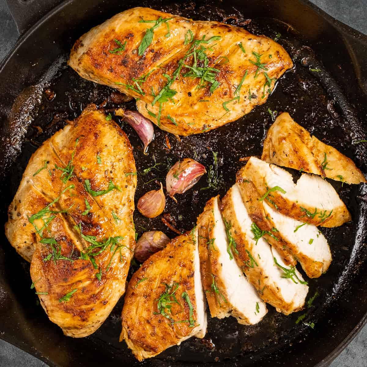 chicken breast being seared in cast iron skillet