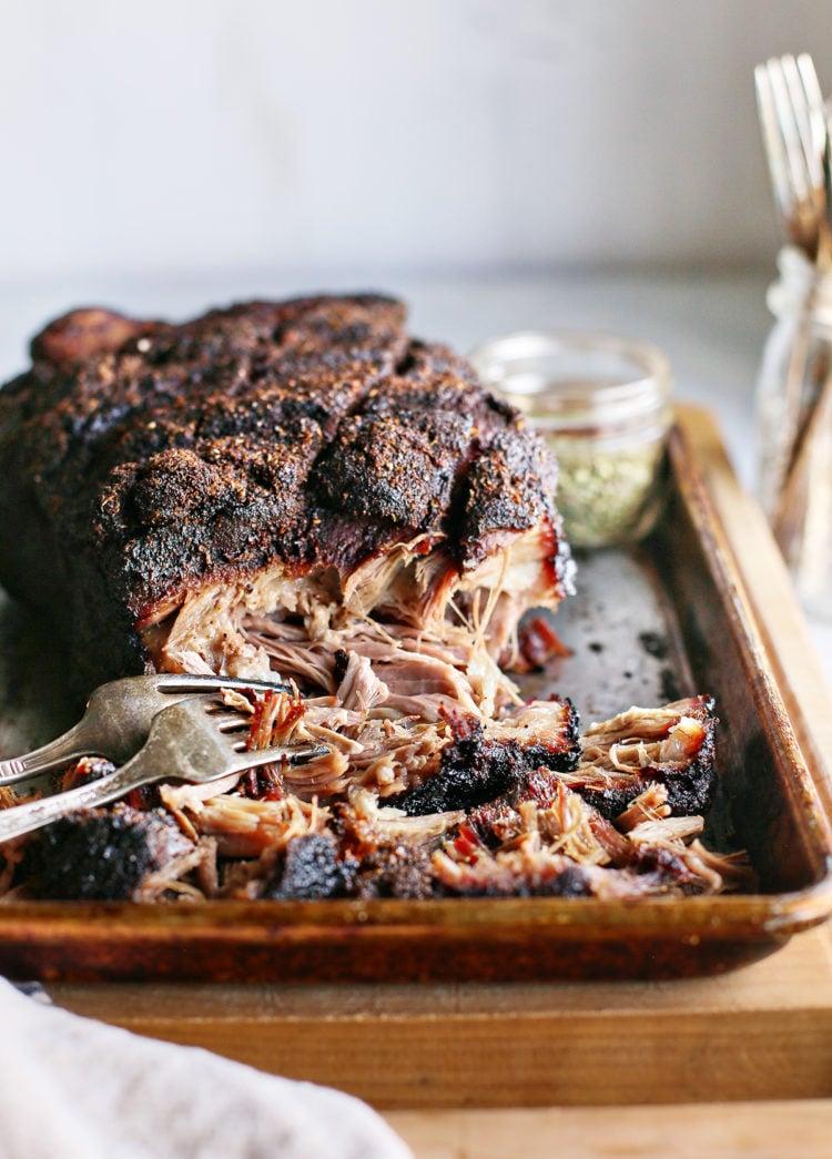 close up of pork shoulder marinating in cider brine in a large bowl