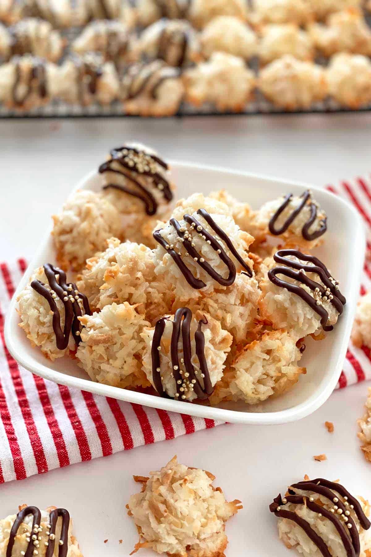 a plate of coconut almond macaroons drizzled with melted chocolate and sprinkled with sea salt