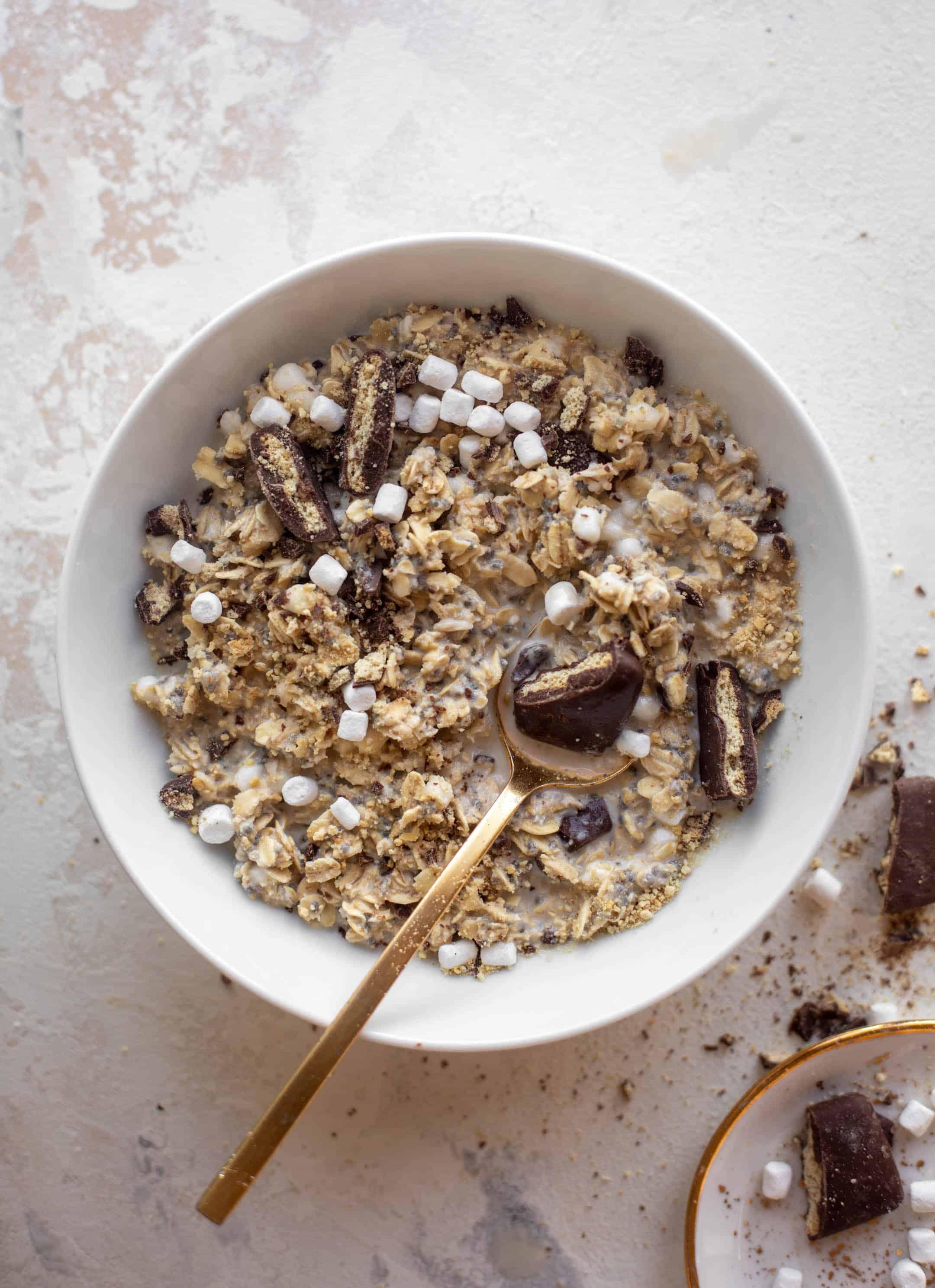 overhead shot of ingredients for s'mores overnight oats laid out on a wooden surface