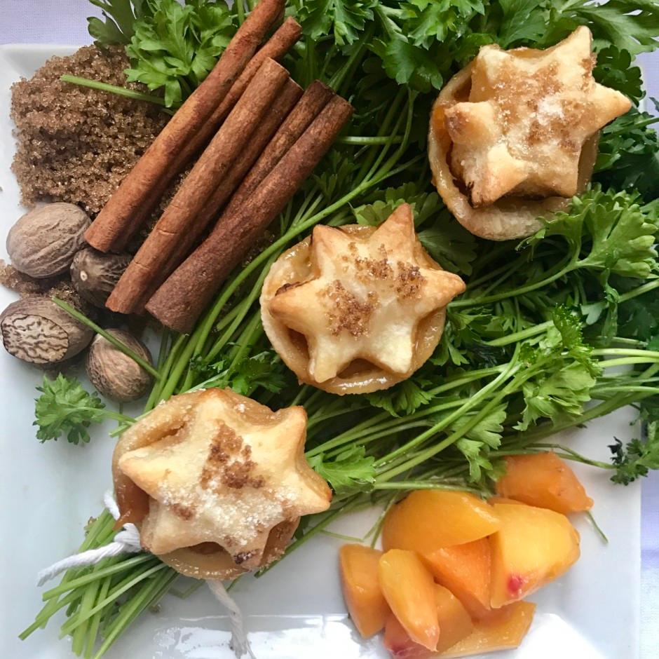 close up shot of petite peach cobbler tarts arranged artfully on a rustic wooden surface