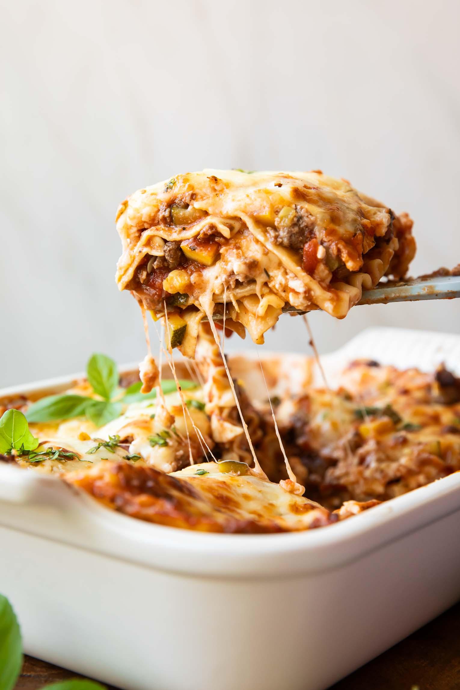 A warm, comforting lasagna dish being taken out of the oven
