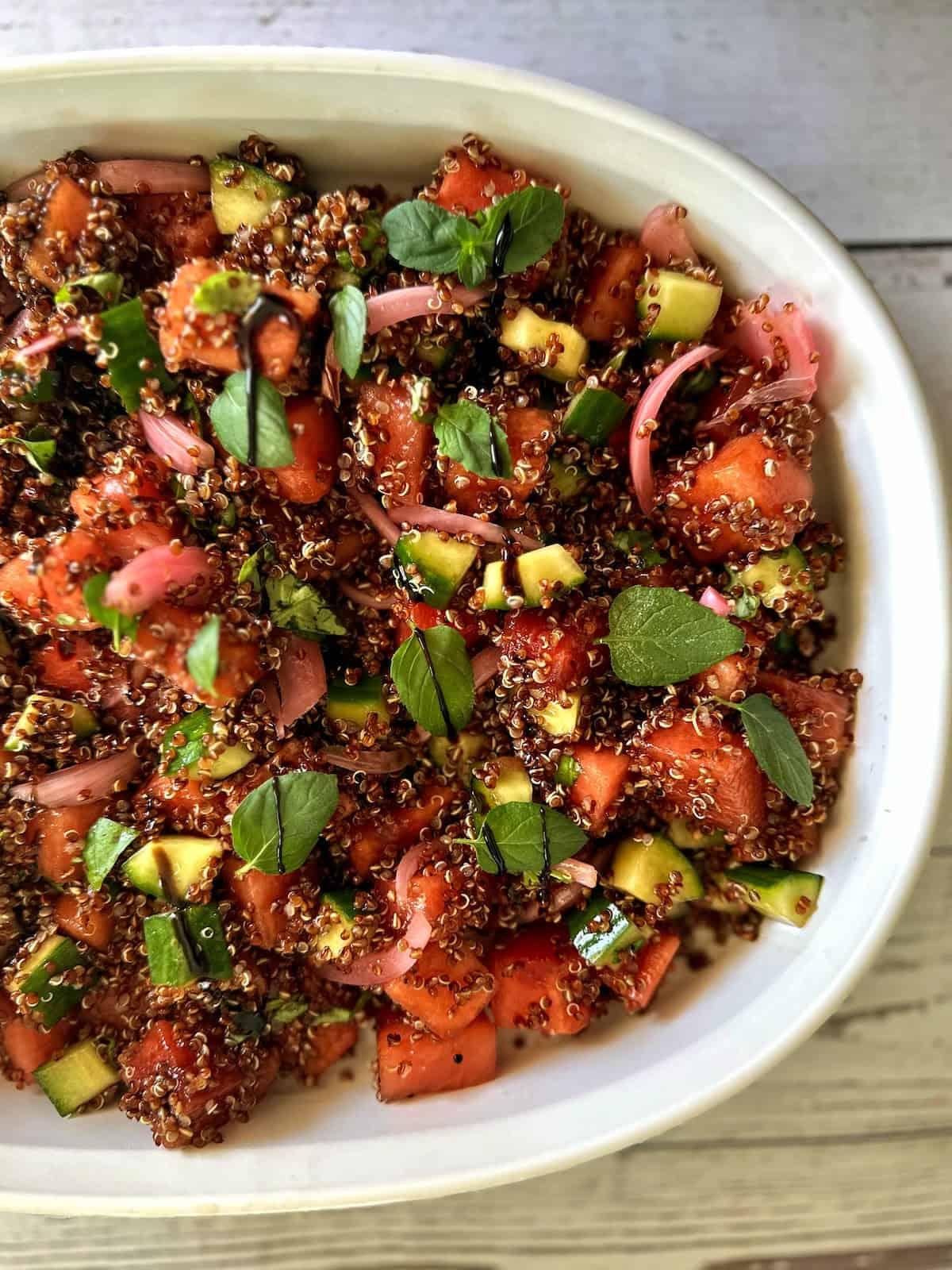 overhead shot of a vibrant watermelon quinoa salad in a large bowl