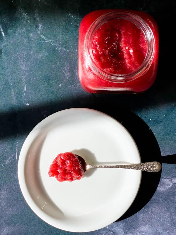 Close-up shot of a spoon scooping up rhubarb and kidney bean compote