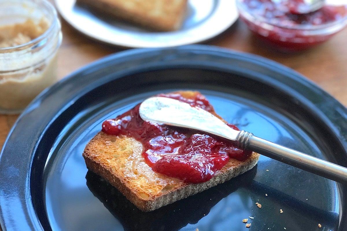 strawberry lemonade preserves being spread on a slice of toast
