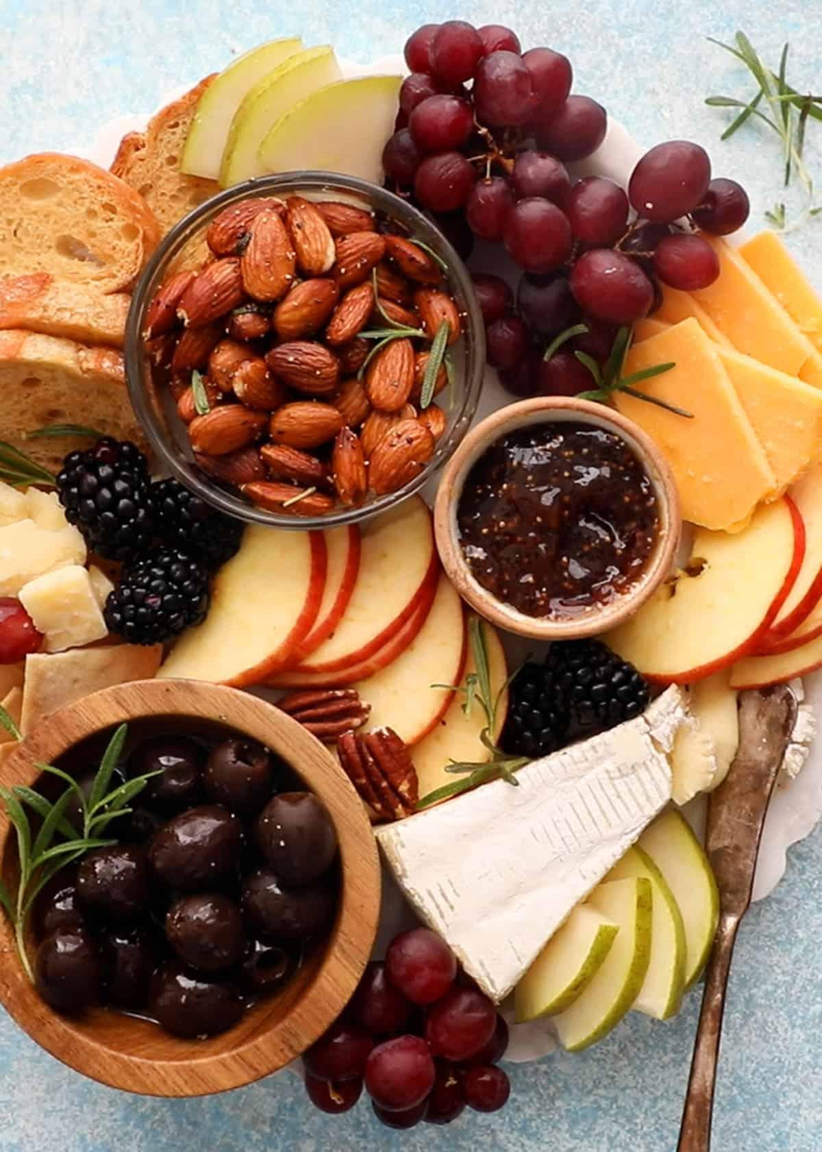 Arrangement of cheese, crackers, fruits, and nuts in a bento box