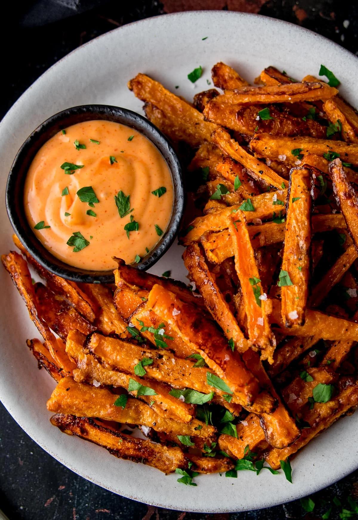 close up shot of buffalo style carrot fries with blue cheese dressing on a plate