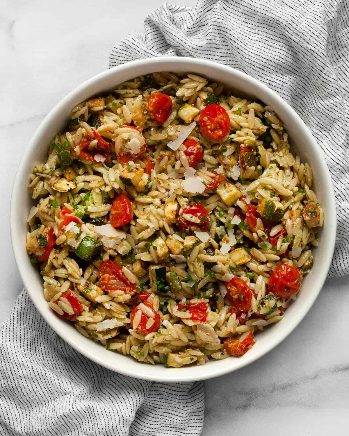 close-up shot of a slice of Mediterranean Zucchini and Orzo Bake showing the textures of the orzo, zucchini, and tomatoes