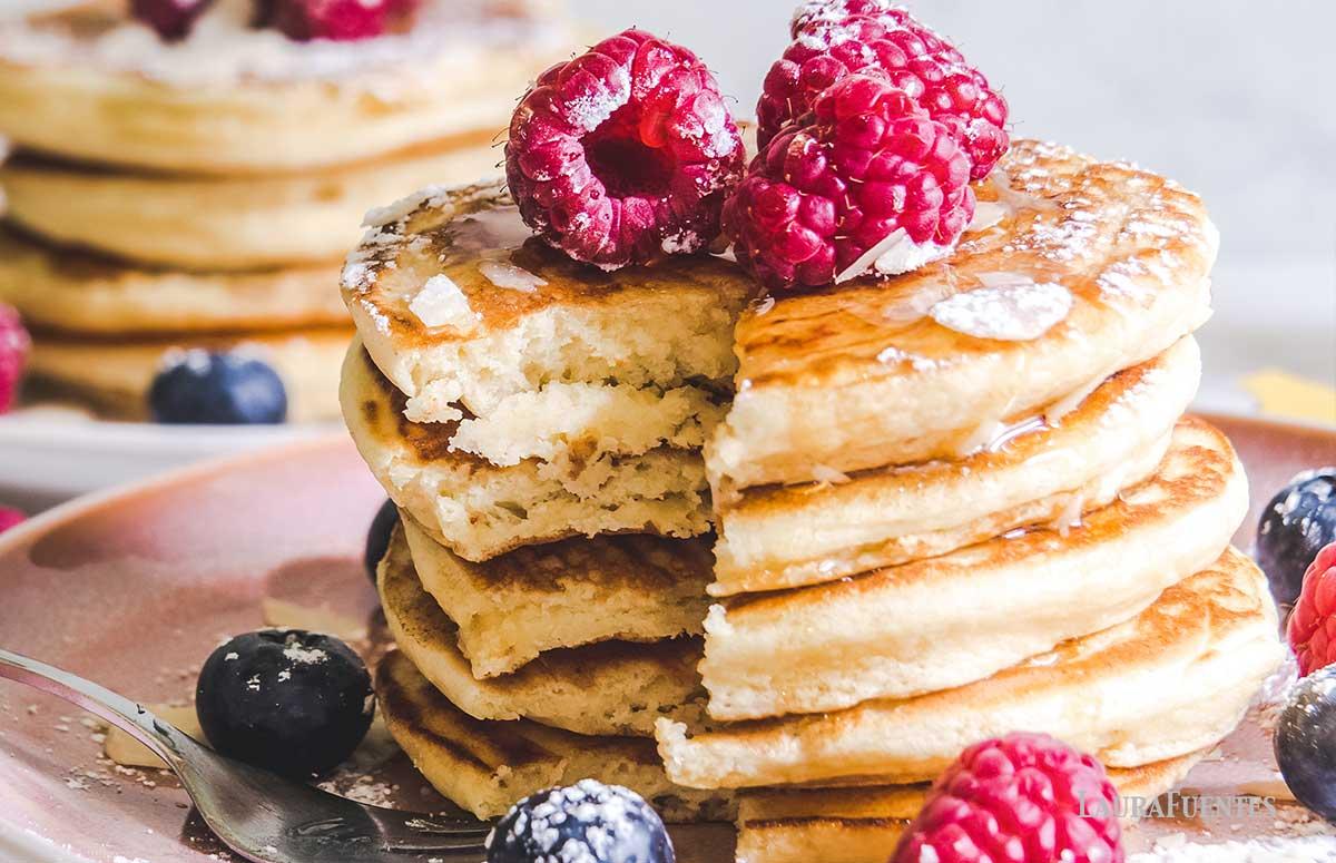 close-up shot of Canadian gluten-free pancakes with maple syrup, berries, and whipped cream
