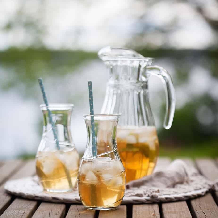 pitcher of jasmine green tea cold brew being poured into a glass with ice