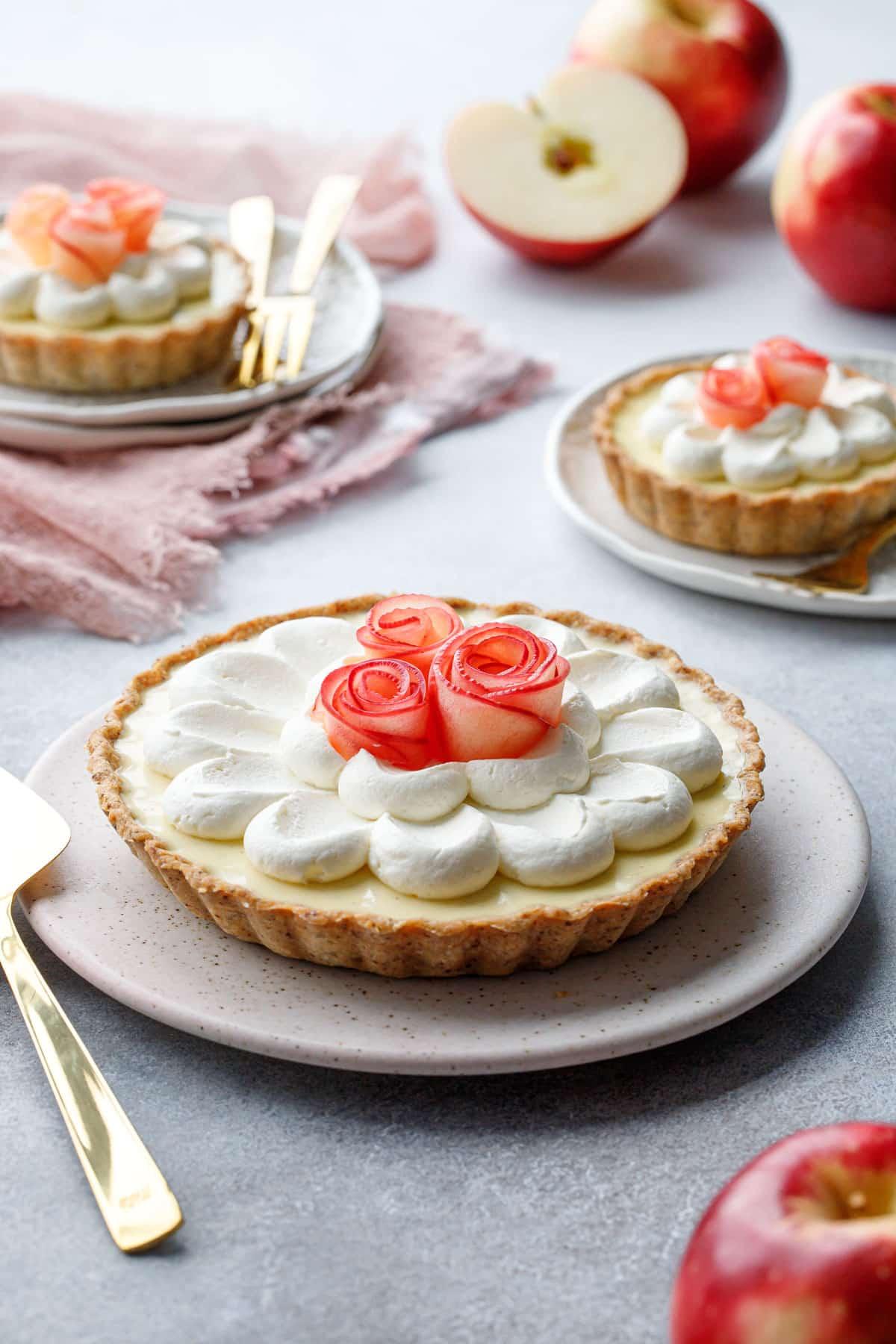 a slice of the salted caramel apple rose tart being lifted, showcasing the layers of apples, crust, and caramel