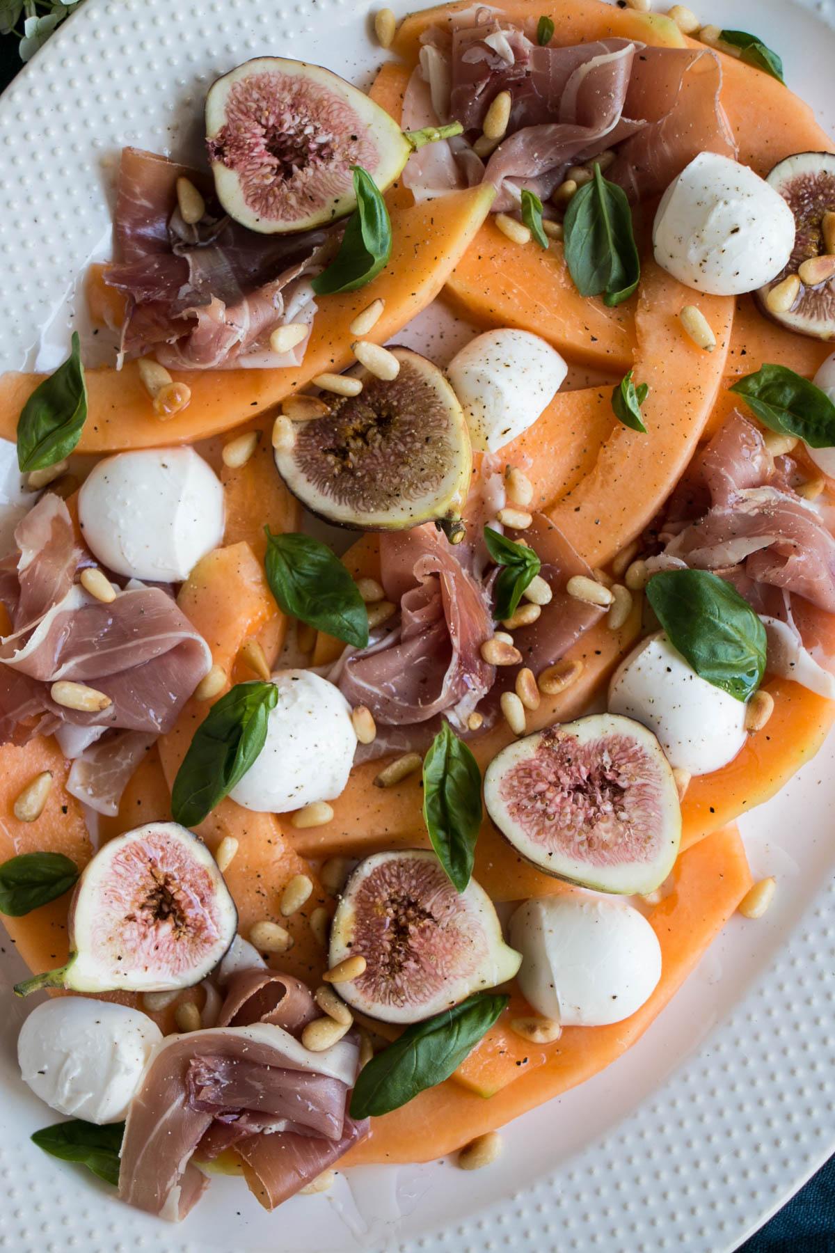 Overhead shot of a Watermelon Prosciutto Fig Salad on a rustic wooden table