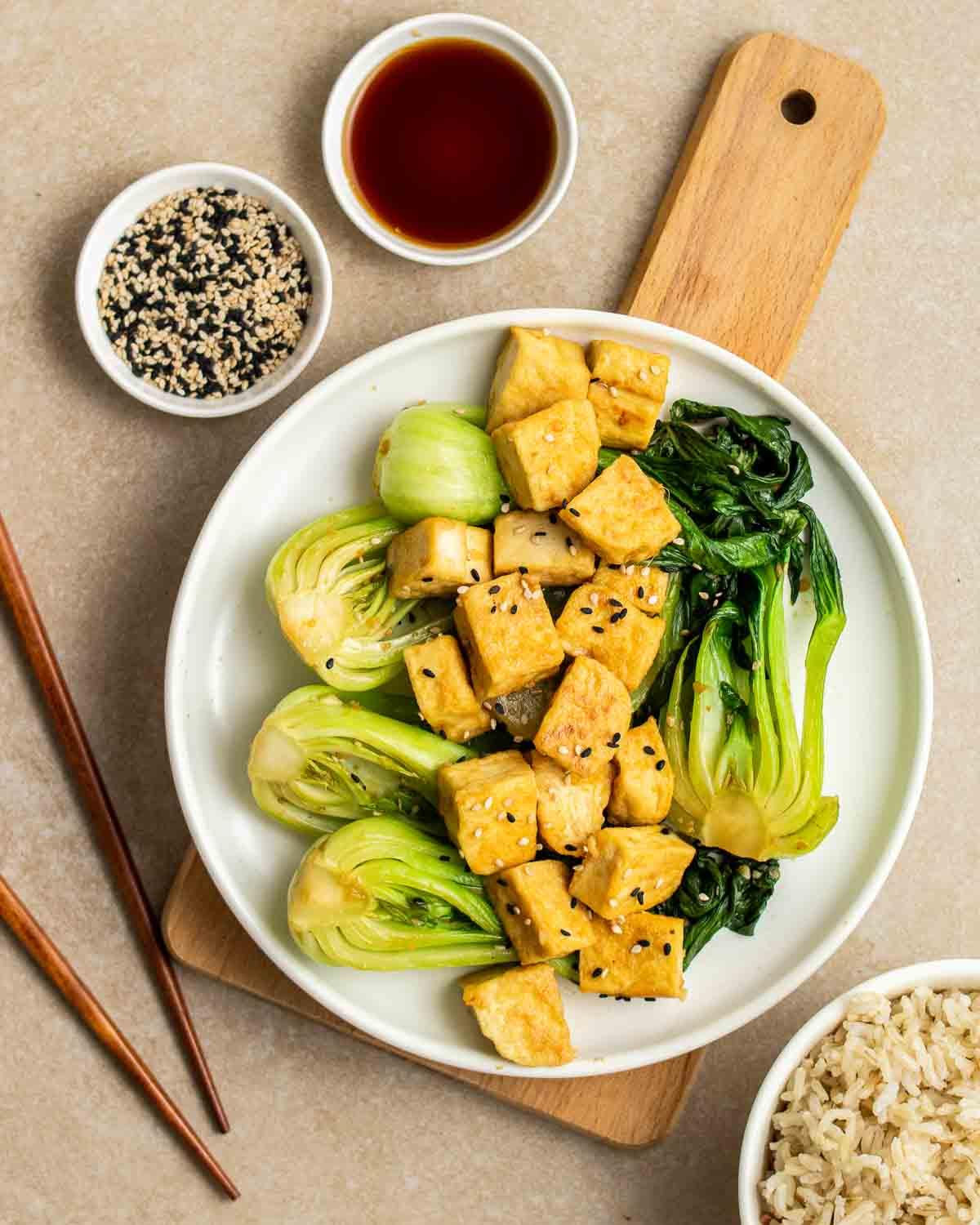 Ingredients for yellow curry tofu stir-fry with bok choy arranged on a wooden board