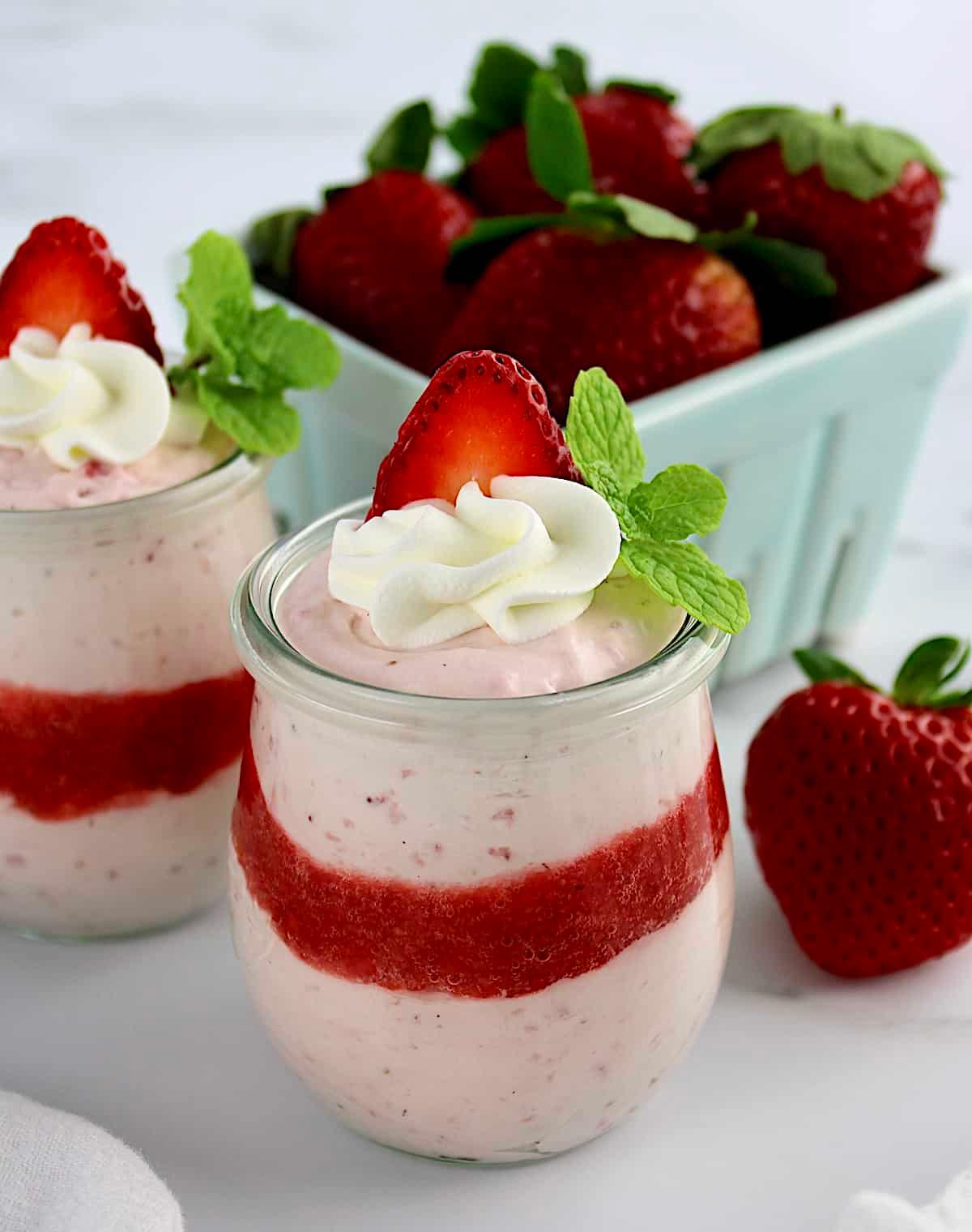 a vibrant strawberry mousse dessert in a clear glass