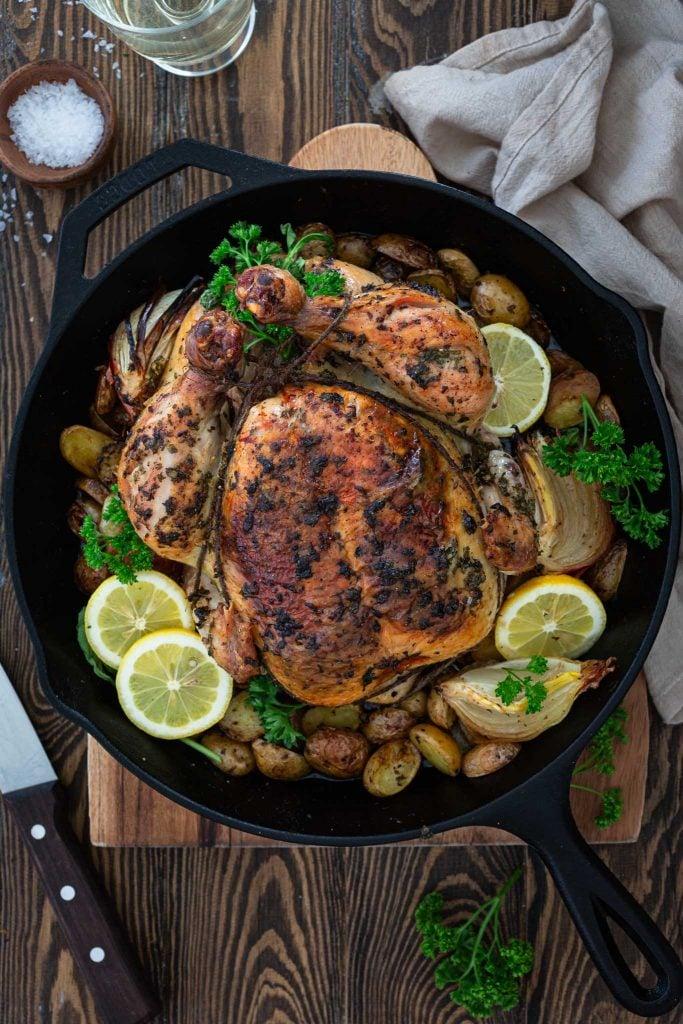 lemon herb roasted chicken with broccoli on a wooden cutting board