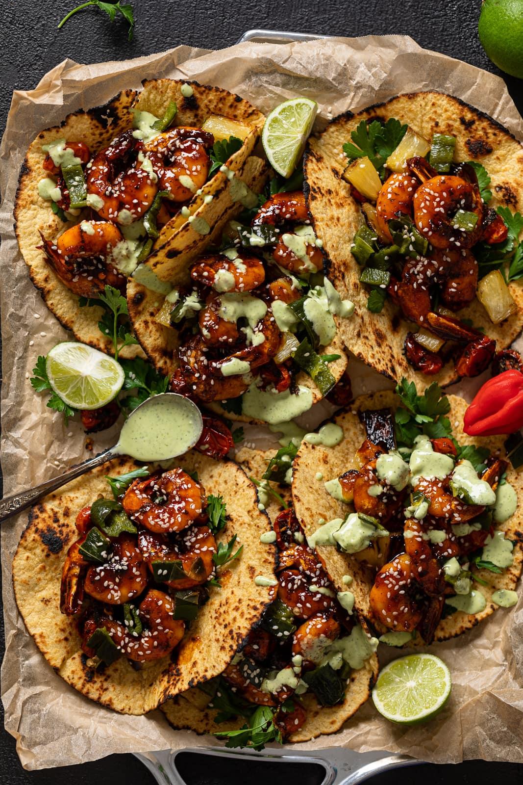 overhead shot of ingredients for crispy shrimp tacos, including shrimp, avocado, tortillas, and spices