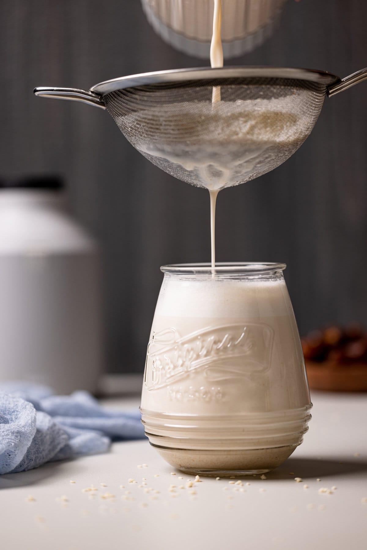 pouring sesame seed milk into a glass