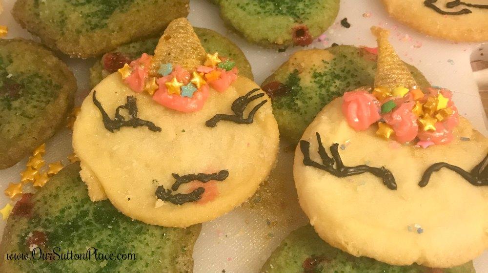 a batch of colorful, decorated summer dragon cookies on a cooling rack
