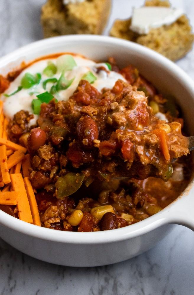 hearty bowl of vegan chili with TVP and toppings