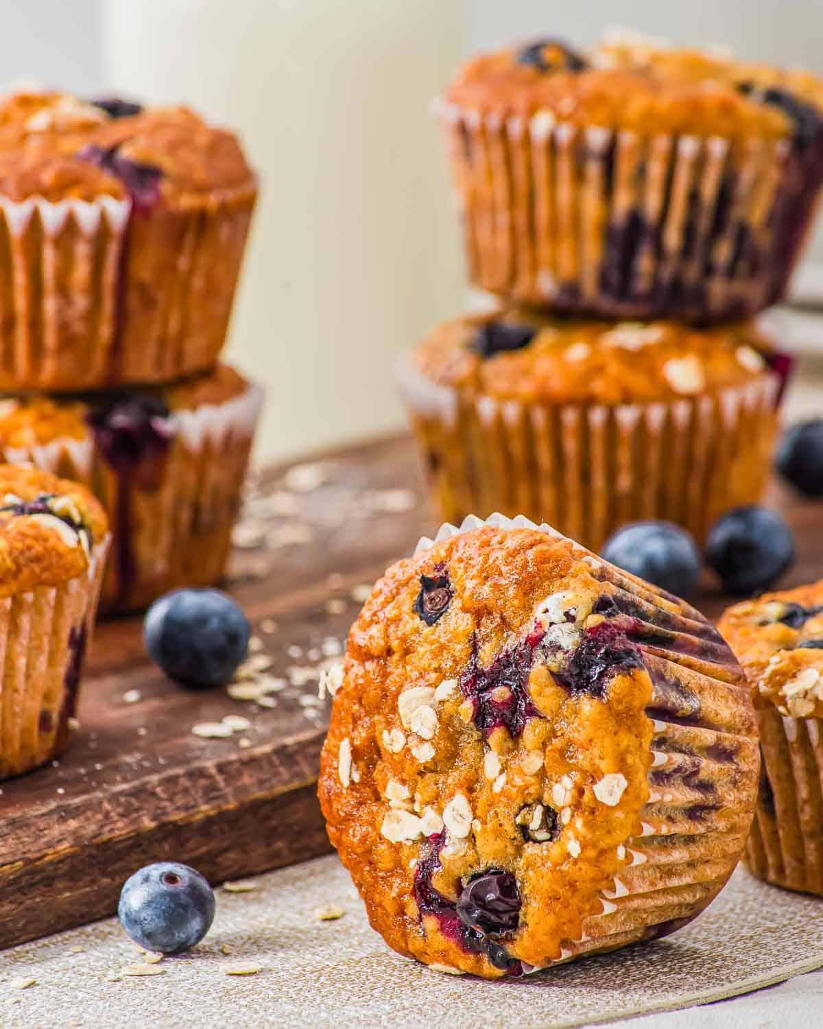 close-up shot of a single blueberry oat muffin with blueberries and oats scattered around