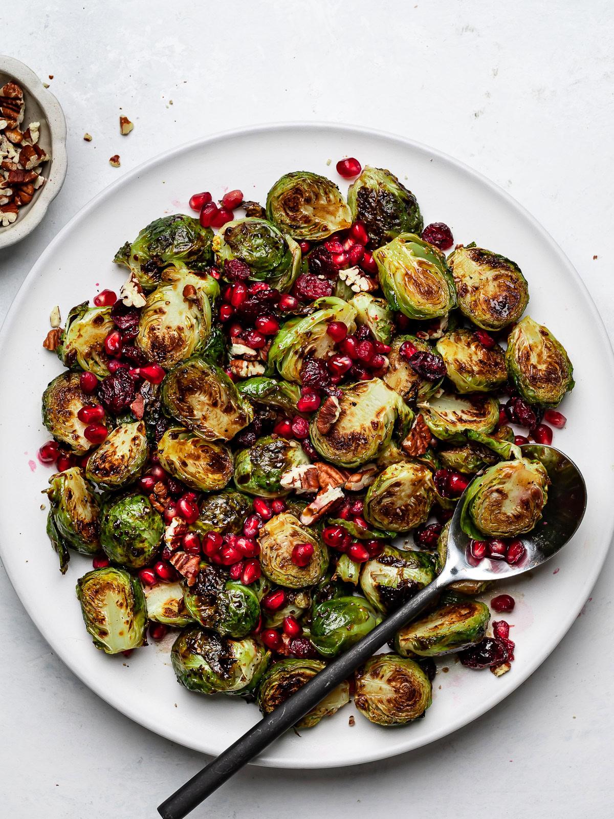 Close-up of roasted Brussels sprouts with balsamic glaze and cranberries served on a rustic wooden board