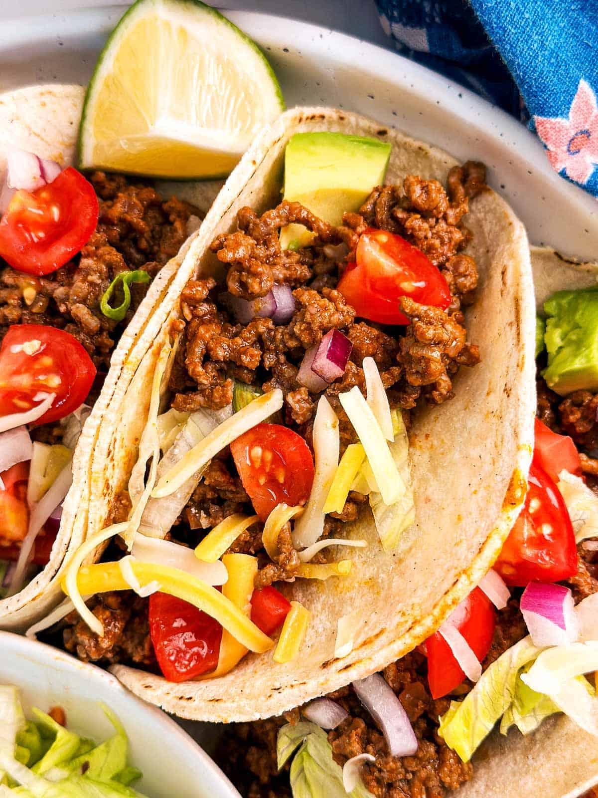 close-up shot of a filled cranberry orange ground beef taco with toppings