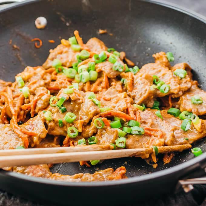 a close up of peanut beef stir-fry being made in a wok