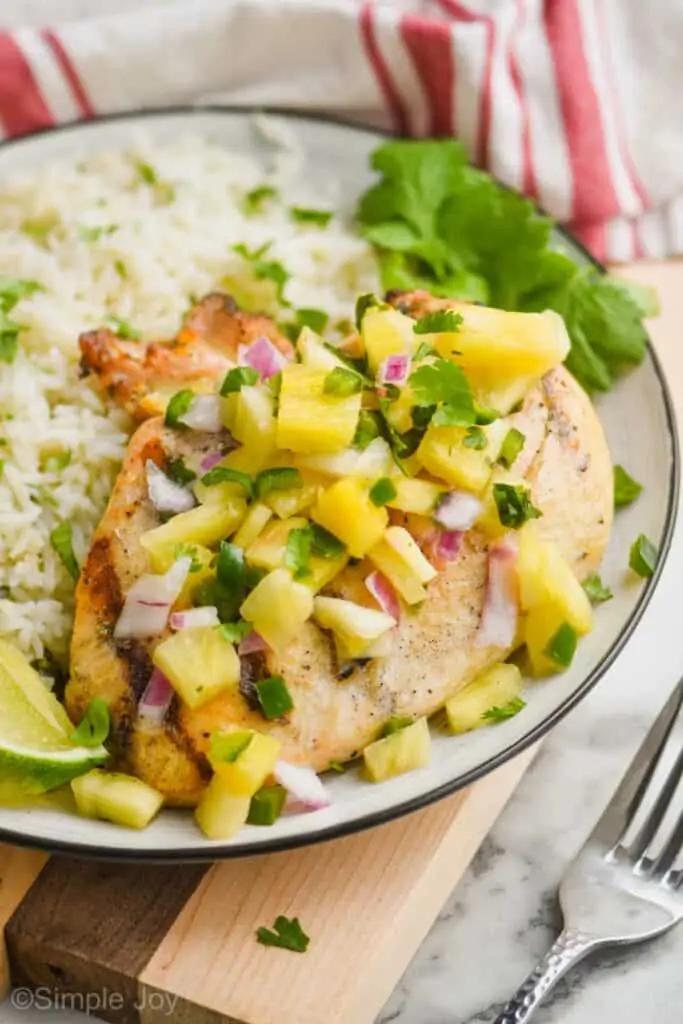 Close-up of a grilled chicken breast topped with pineapple salsa