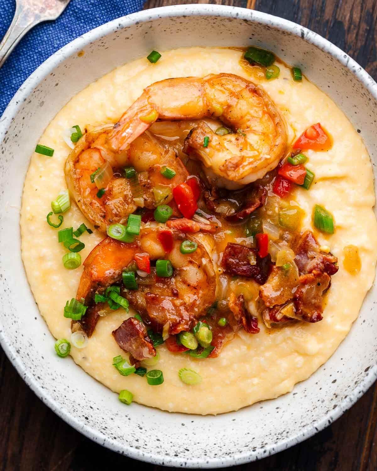 a bowl of shrimp and grits topped with green onions